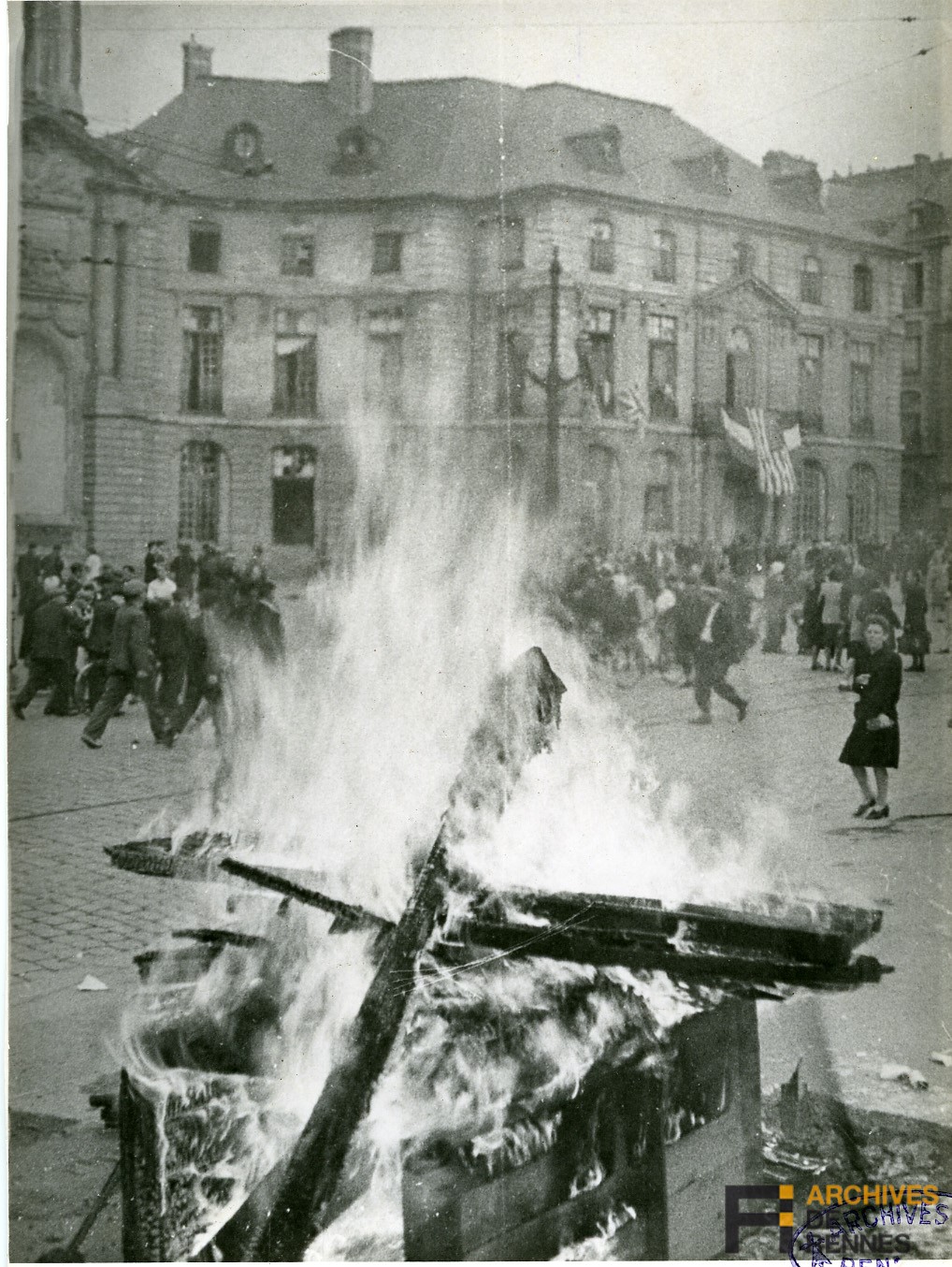 Photo : À bas l'occupation ! Sur la place de la mairie les Rennais brûlent les objets symbolisant la soumission.